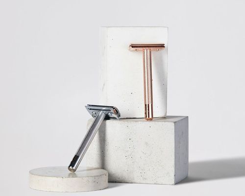 Silver and gold razors against a white background