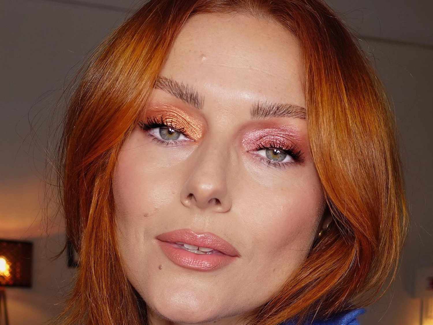 Katie Jane Hughes with velvet eyeshadow (orange on one eye, pink on the other) and pink glossy lips