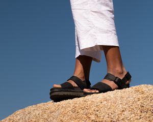 Feet in sandals standing on a rock