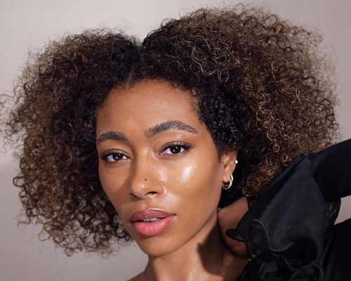 woman with curly hair looking at camera