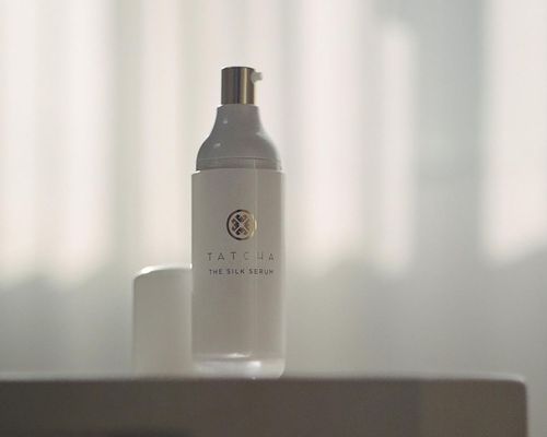 A bottle of Tatcha's The Silk Serum on a table