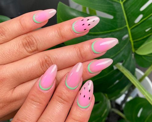 Manicure with watermelon pink base, green cuticle "rind", and black dotted seed design