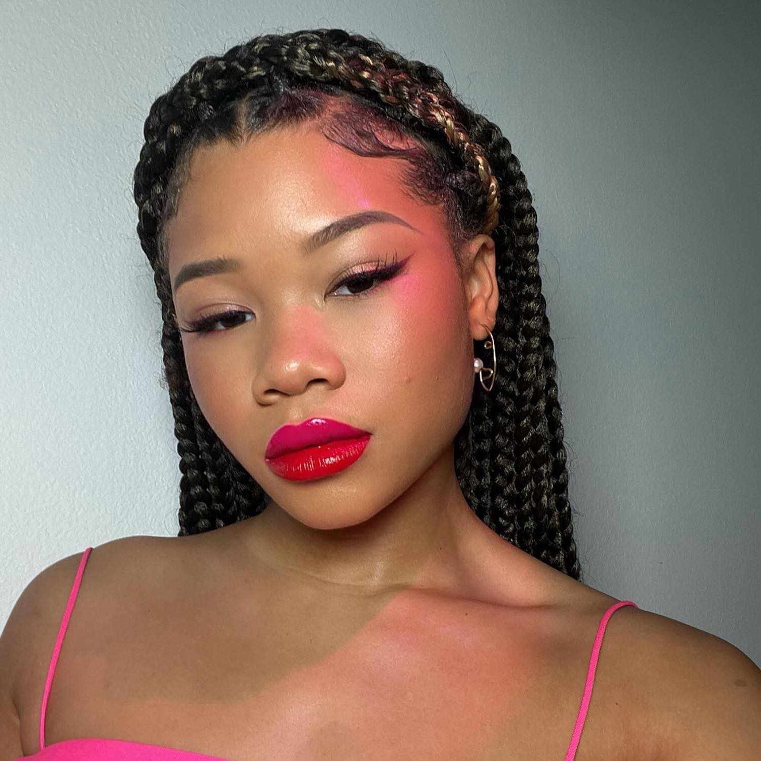 Storm Reid wears a radiant makeup look with two-toned pink and red glossy jelly lips