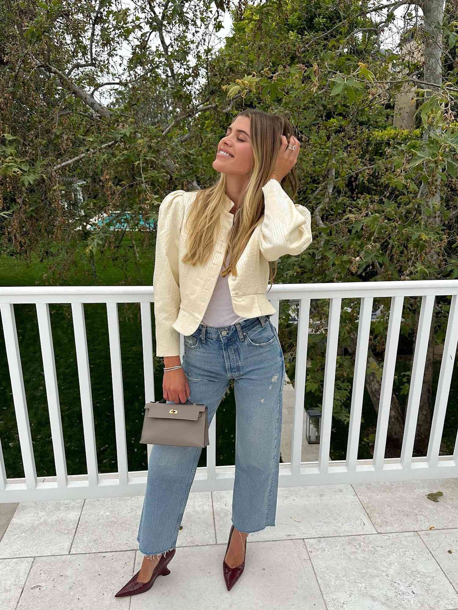 Sofia Richie Grainge wears wide leg jeans, a puff sleeved blazer, pointed-toe heels, and a white shirt