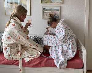 Matilda Djerf and friend laughing while drinking wine in fruit-patterned robes