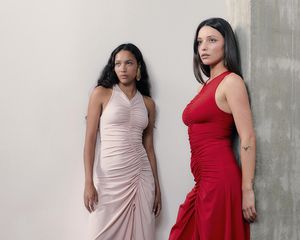 Two models wearing ruched red and pink dresses by Lamara London