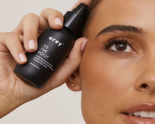 Arey model holding To The Root serum by face