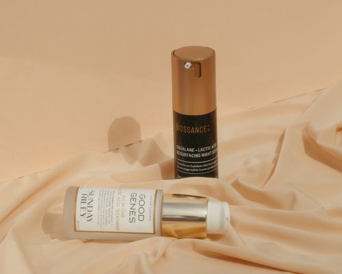 AHA serums on a peach satin sheet