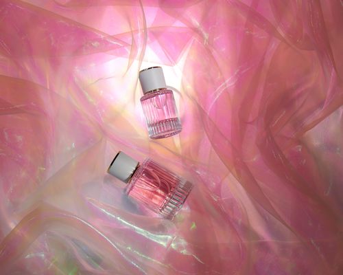 Transparent glass perfume bottles in folds of chiffon fabric