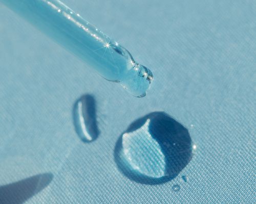 A drop of blue liquid on a blue background.