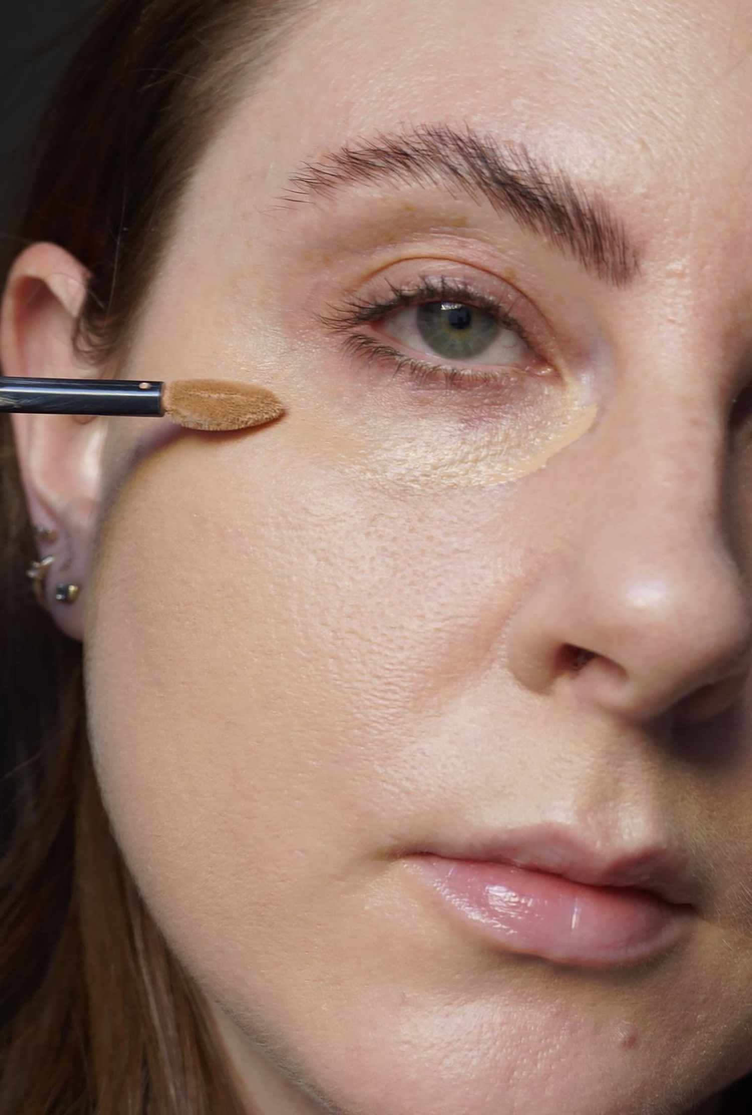 The author applies concealer under her eyes