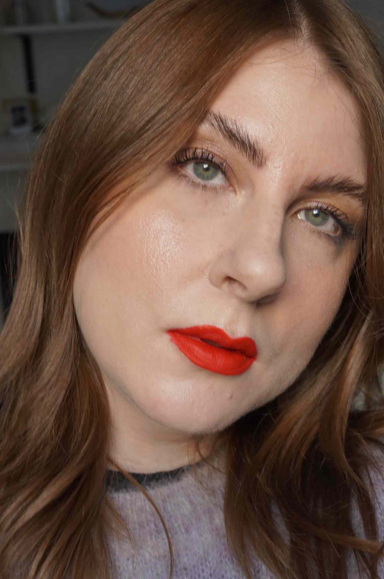 The author's complete makeup look, featuring a glowy, baked base and red-orange lips