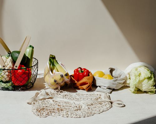 Close up of fruits and vegetables against a beige background