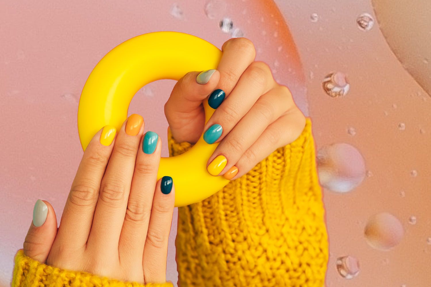 Photo composite of a woman holding a rubber ring, showing off their multi-colored manicure.