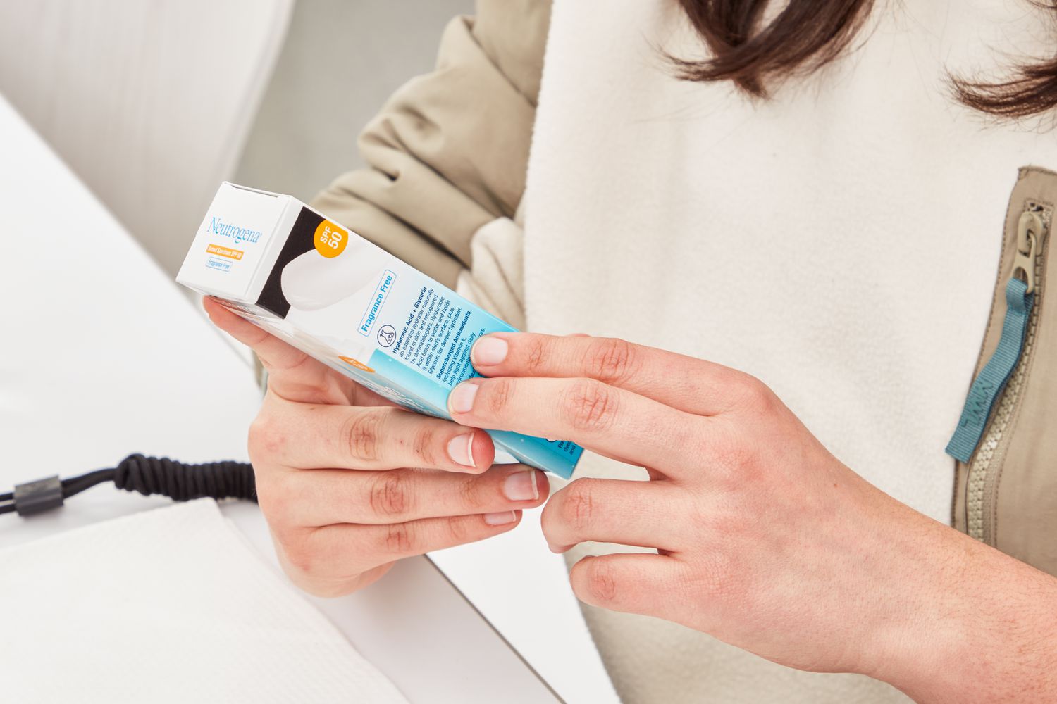 Person reading information on the box of the Neutrogena Hydro Boost Hyaluronic Acid Moisturizer SPF 50