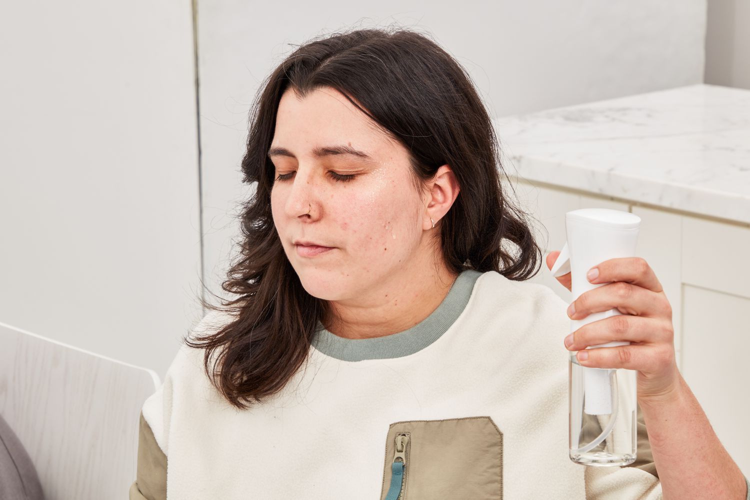 Person spraying water on their face during product testing of the Neutrogena Hydro Boost Hyaluronic Acid Moisturizer SPF 50