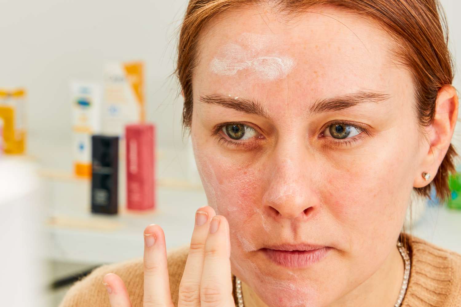 Closeup person applying Coola Classic Face Organic Fragrance-Free Sunscreen Lotion to their face