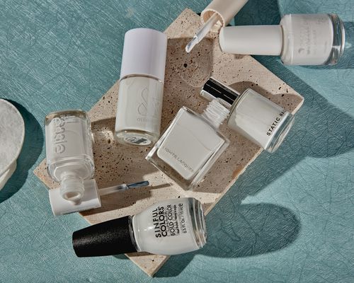 multiple white nail polishes displayed on a granite block