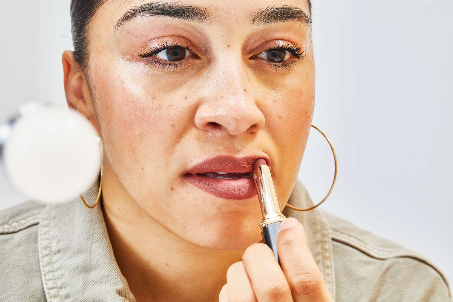 A person applying the L'OrÃ©al Colour Riche Intense Volume Matte Lipstick on their lips