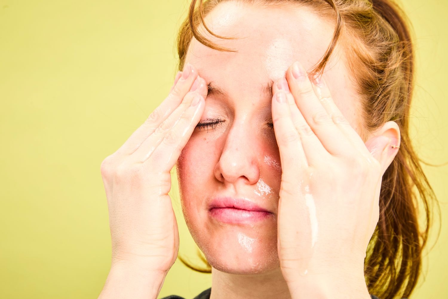 A person rubbing their eyebrows with Dermalogica Precleanse Cleansing Oil