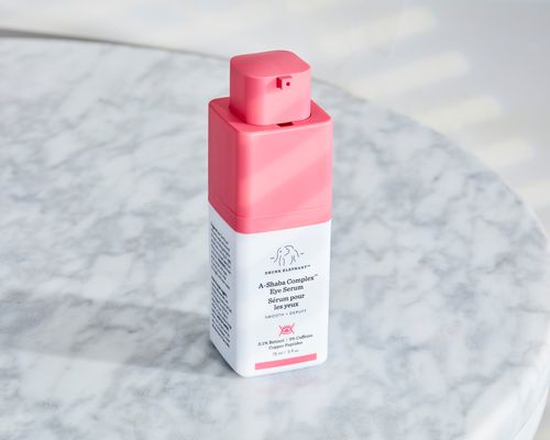 A bottle of Drunk Elephant A-Shaba Complex Retinol Eye Serum with Caffeine + Copper Peptides on a marble table.