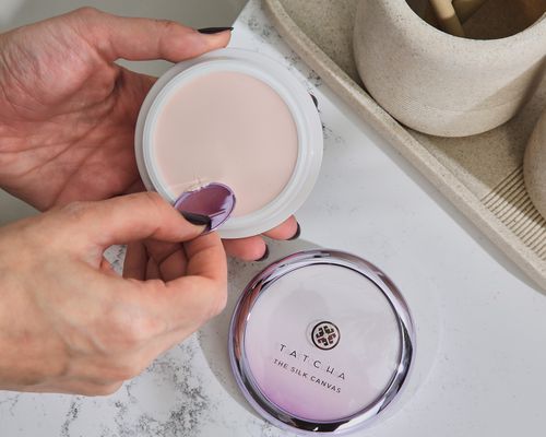 Hand inserts spatula into pot of Tatcha The Silk Canvas Face Protective Primer