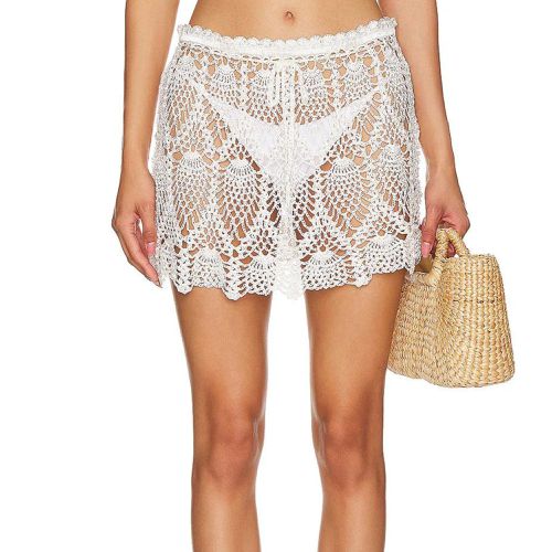 Frankies Bikinis Capri Mini Skirt in white crochet on model styled with white bikini bottom and woven handbag