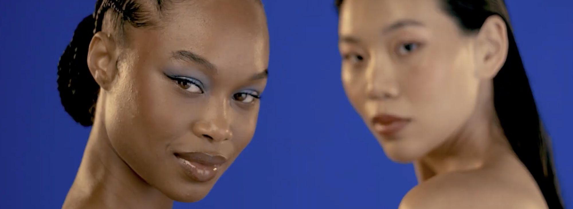 Two models on blue looking at the camera