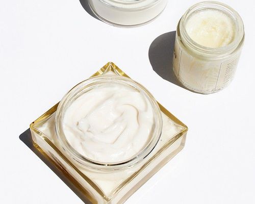 Three jars of body cream displayed on a white surface