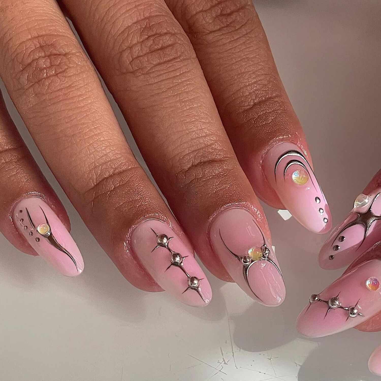 A baby pink manicure with chrome details