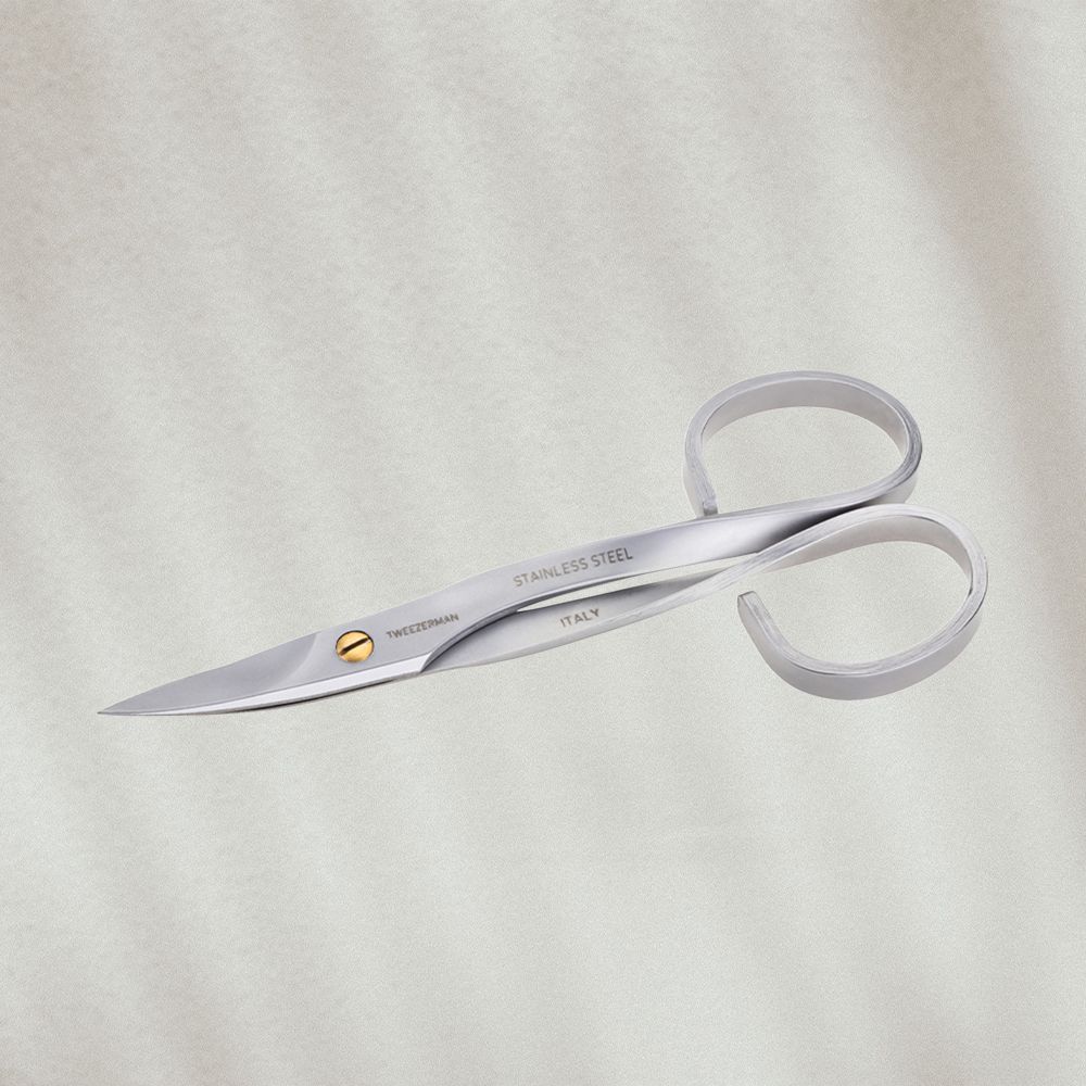 Pair of beauty scissors on textured background