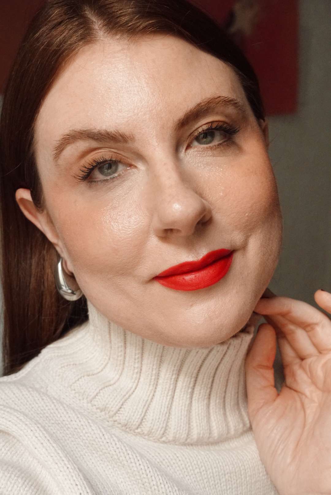 woman posing in a natural makeup look with a bold red lip