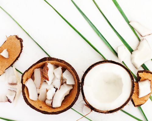 Pieces of coconut and coconut shell on white background