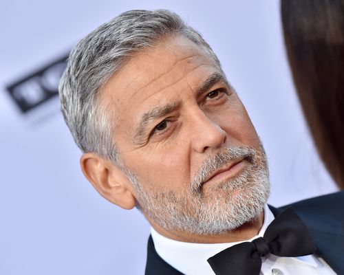 george clooney in a tux walking red carpet