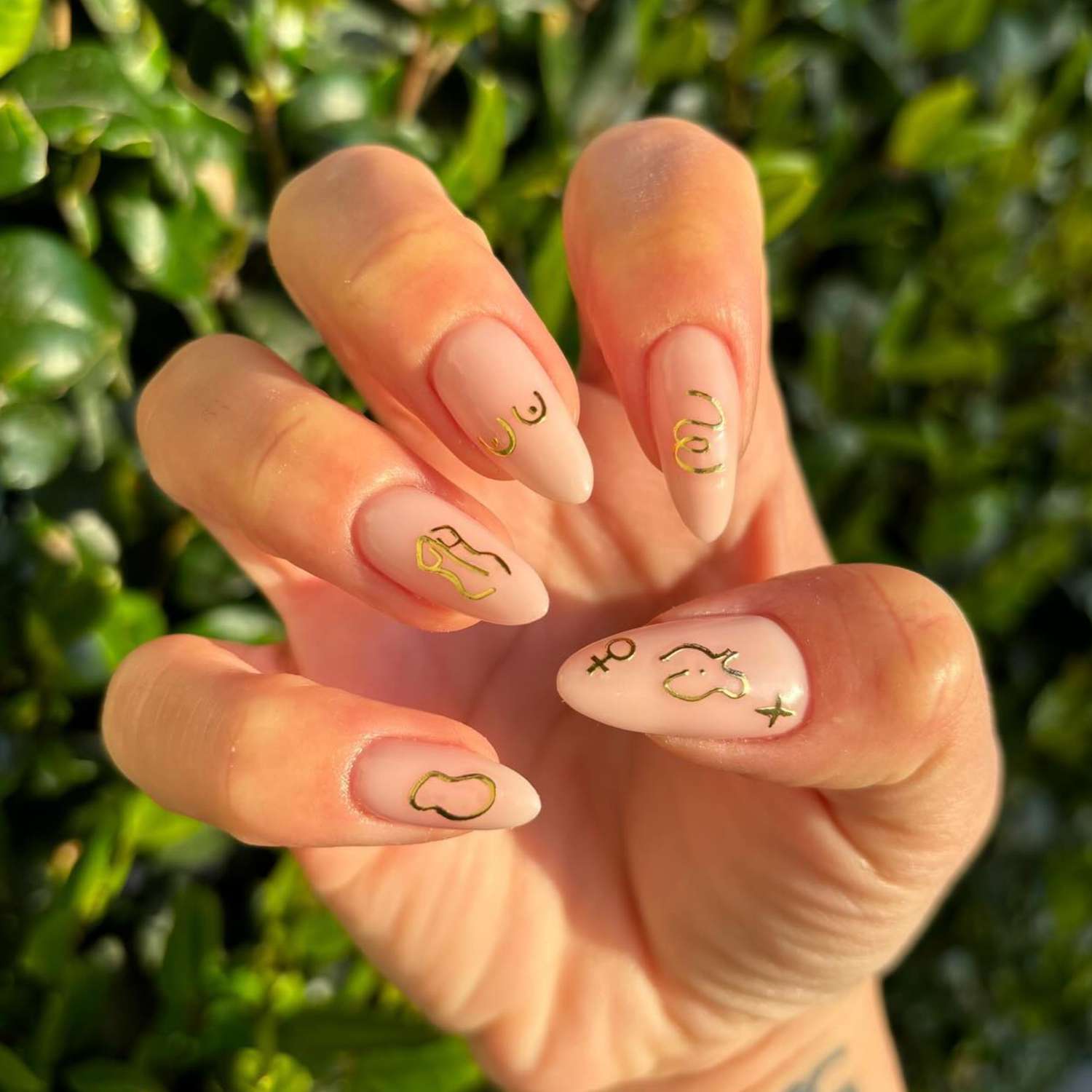 Metallic gold female silhouette nail stickers on neutral manicure