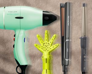 Hair styling tools arranged on a sand colored background