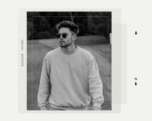 Man in sweatshirt with sunglasses outside in black and white photo