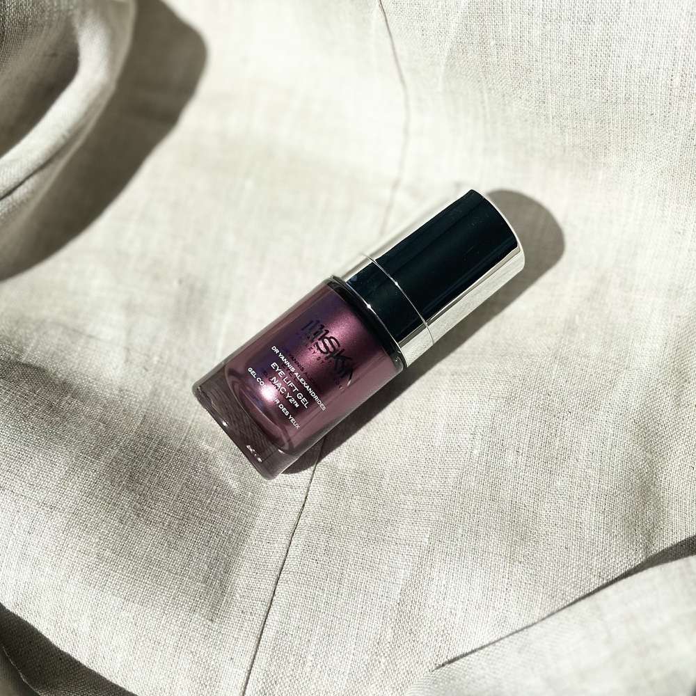 bottle of purple 111 skin eye cream on linen background