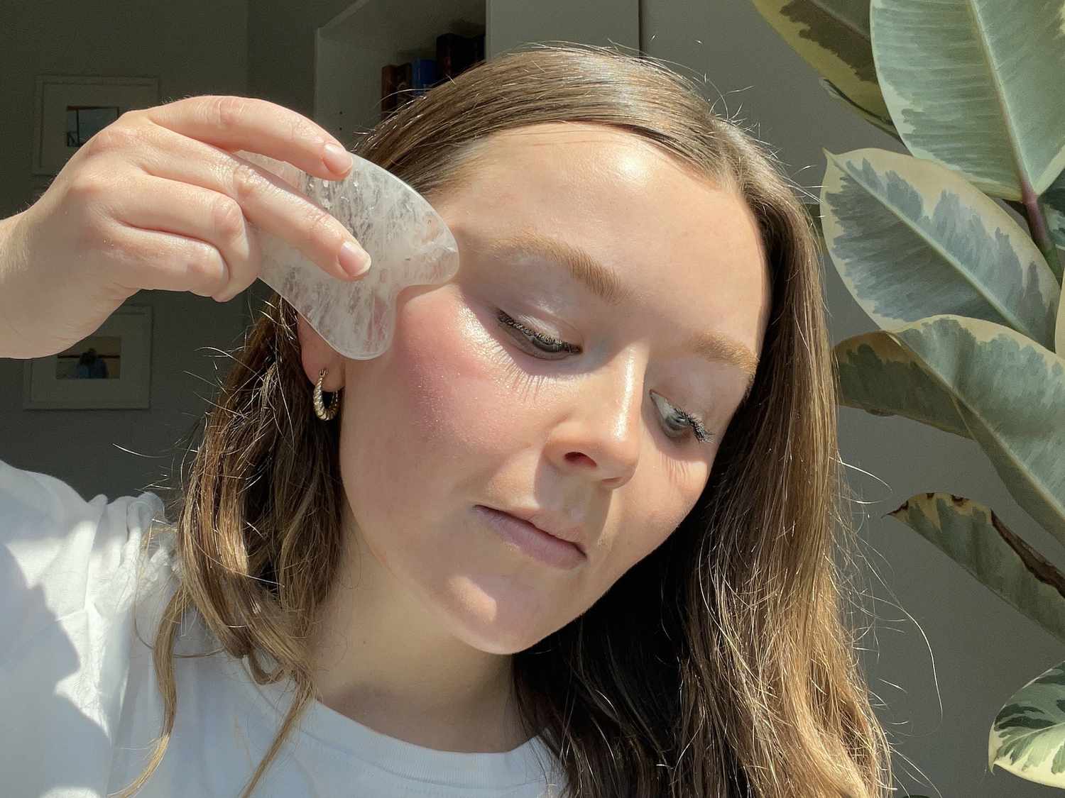 woman using gua sha on under-eye area