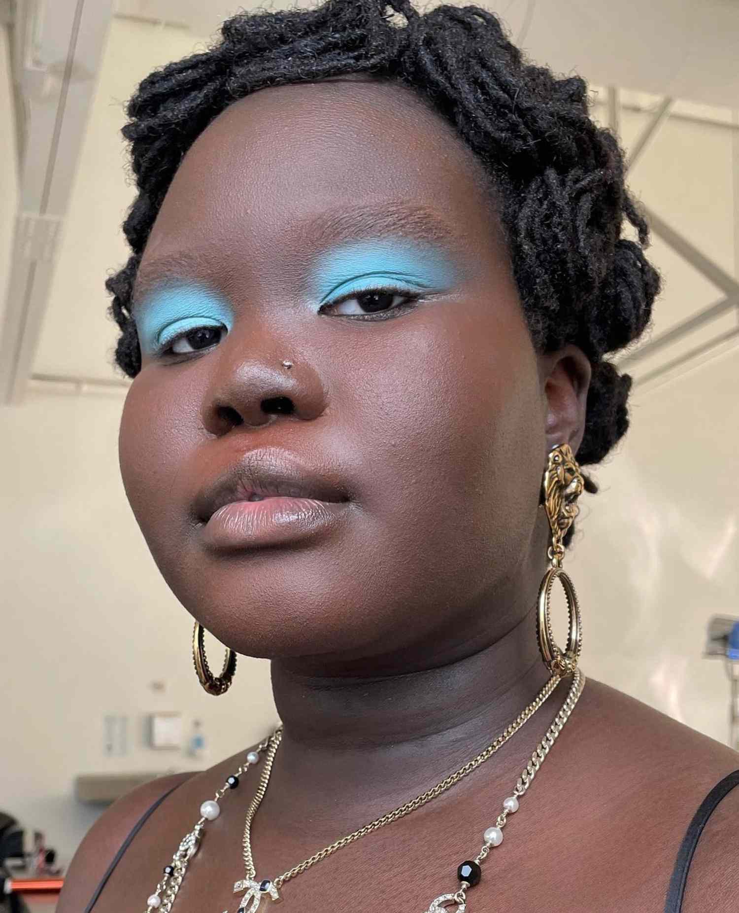 model is wearing a bold baby blue matte eyeshadow look