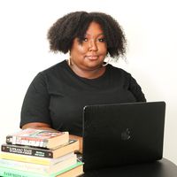 Keyaira Boone at a desk with a laptop, surrounded by books