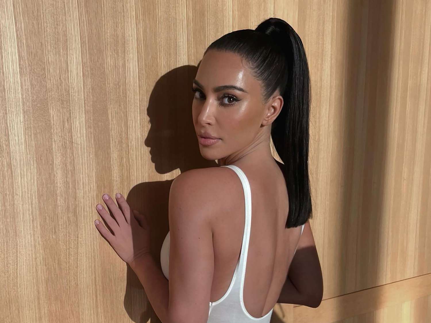 Kim Kardashian viewed from the back, looking at the camera