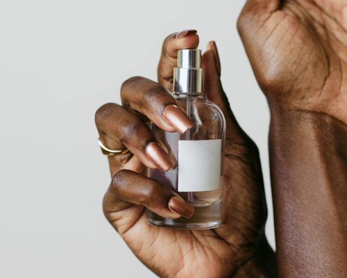 nail polished hands applying perfume