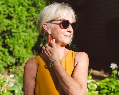 A silver-haired woman smiling in the sun