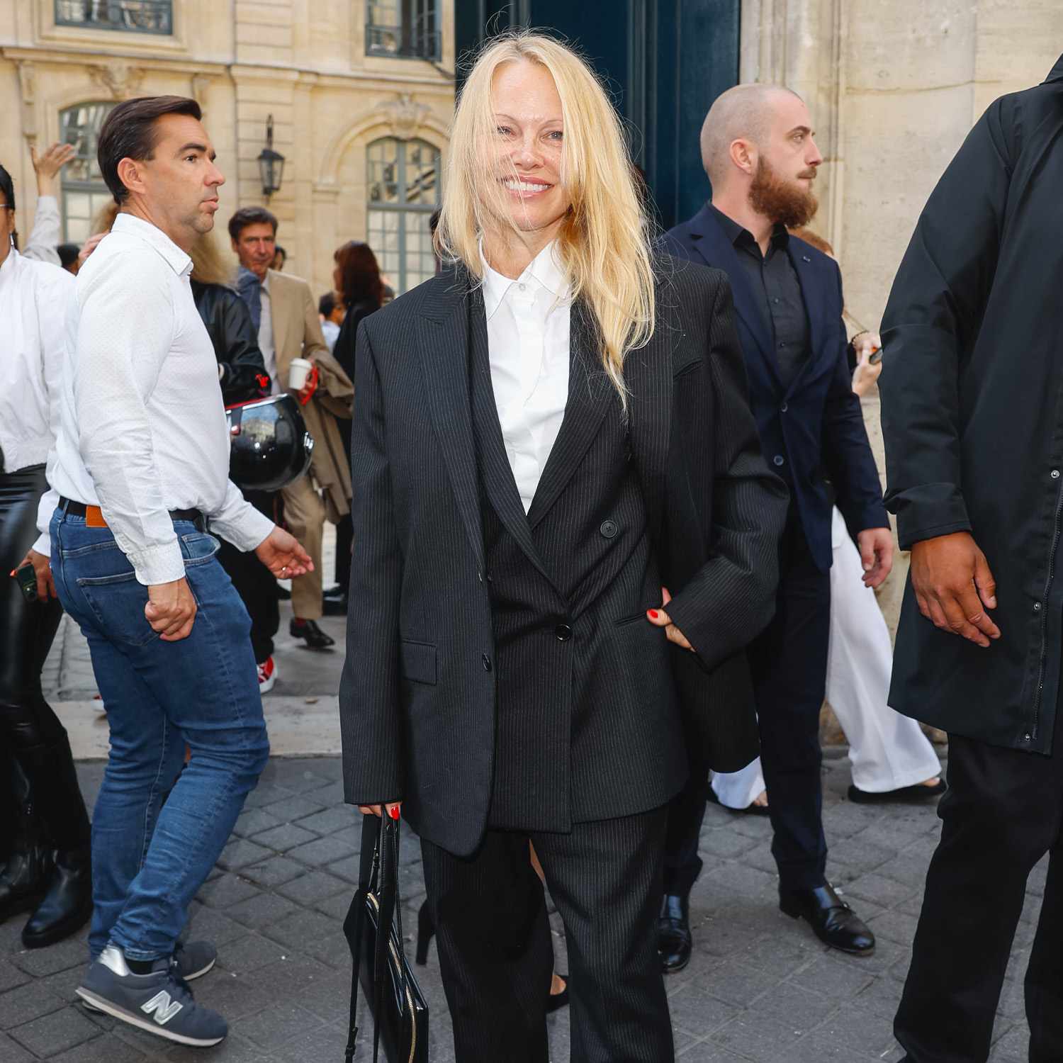 Pamela Anderson at The Row show at Paris Fashion Week with no makeup and an oversized suit