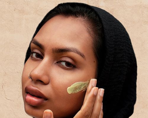 model applying mask to her face