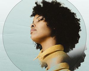 woman with curly hair looking away with eyes closed