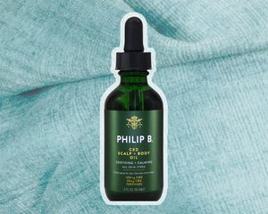 Philip B CBD Scalp + Body Oil on a blue background