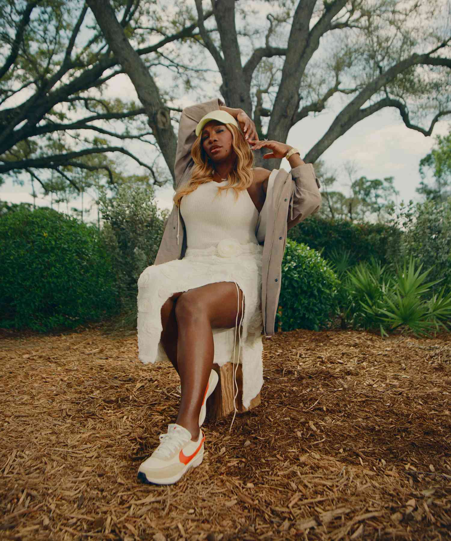 Serena Williams Sitting in a White Floral Skirt White Tank Top Yellow Baseball Hat