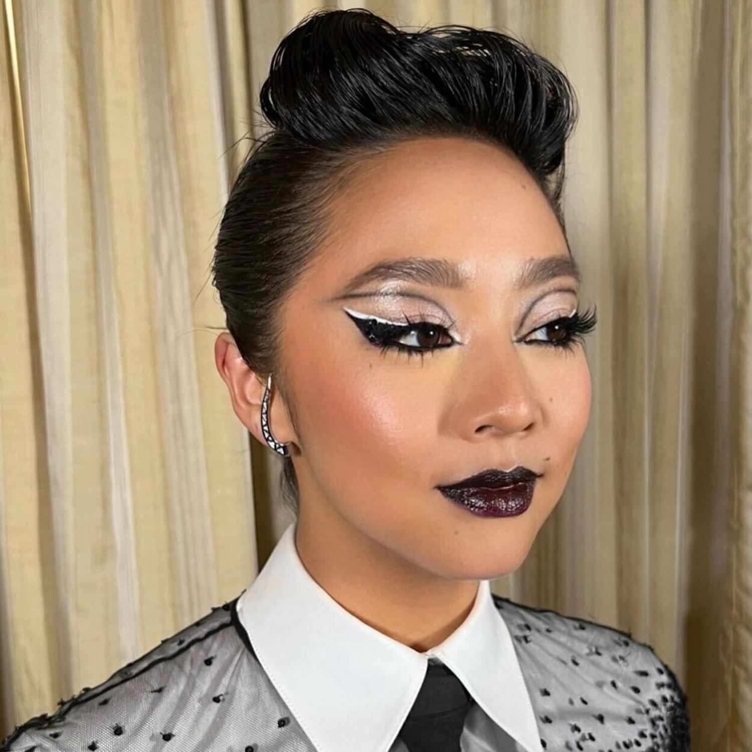 Stephanie Hsu wears a dramatic black and white eye makeup look and dark jelly lips